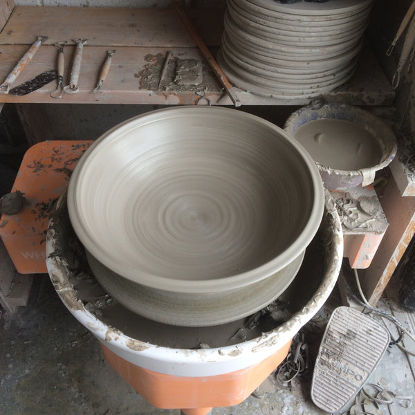 Making plates on the potter's wheel